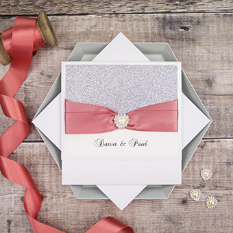 Handmade wedding invitations by Mandy Price of Elegant Creations with beautiful silver glitter and coral ribbon.